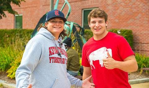 Two students pose for the camera; one gives a thumbs up